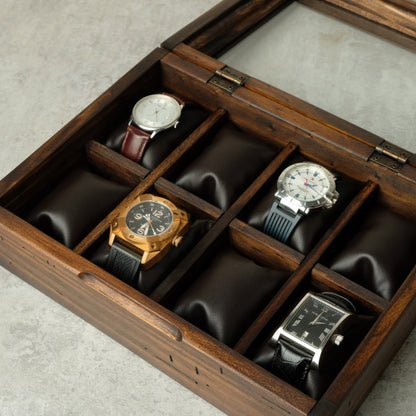 A wooden watch box with a glass lid, shown open to display eight watches.
