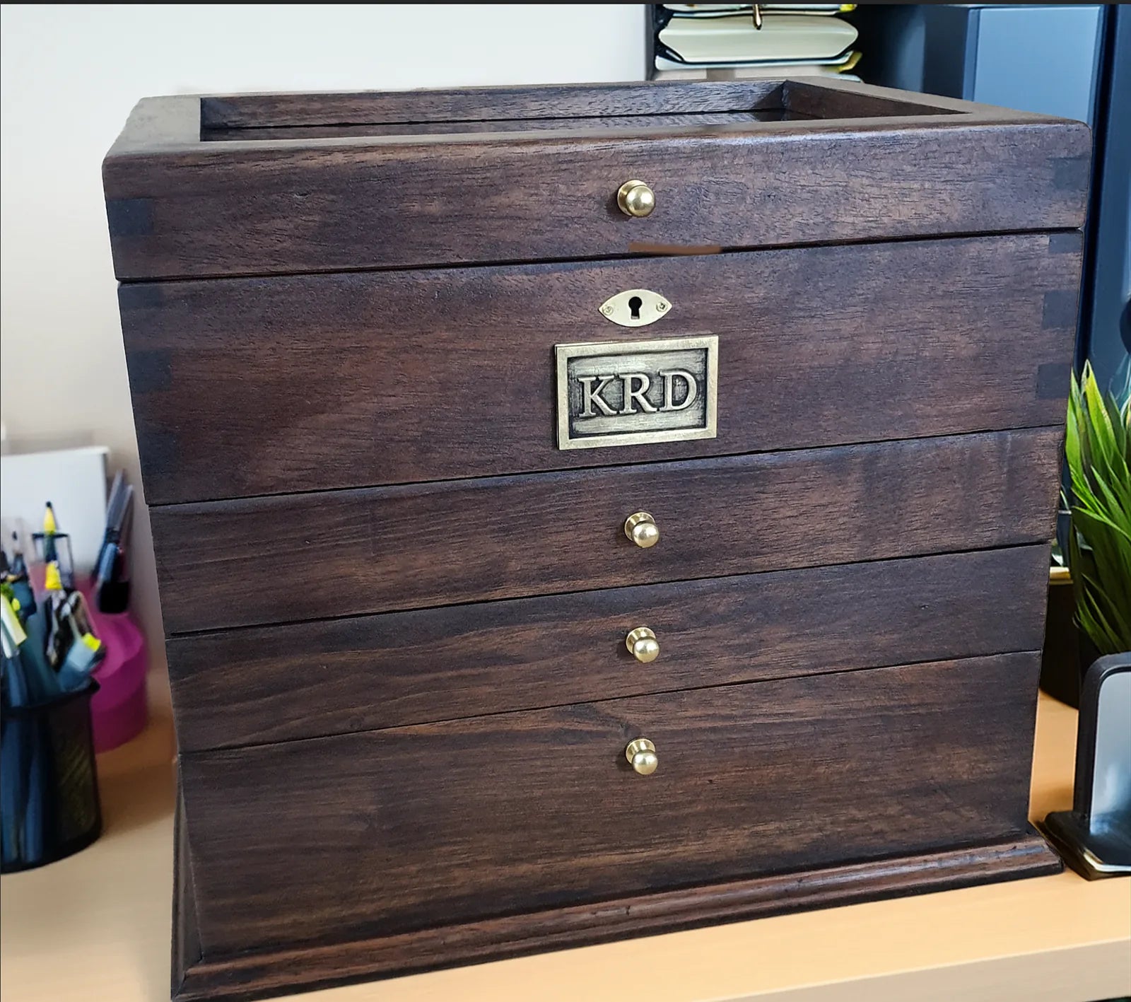 Customer photograph of a tall multi-drawer Deferichs box personalized with a KRD nameplate and brass hardware.