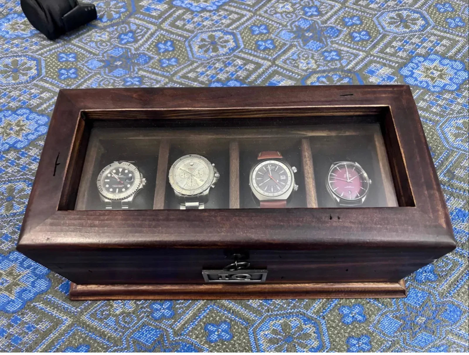 A handcrafted Deferichs dark walnut watch box displaying four watches in a customer’s home.