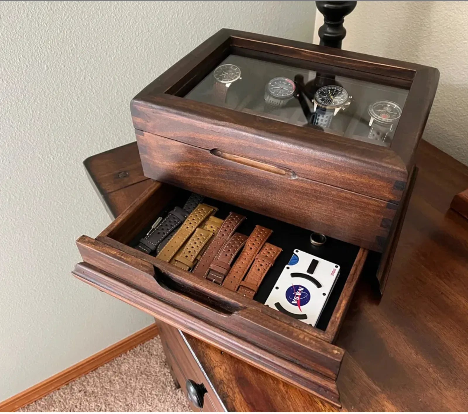 A Deferichs watch box with an open drawer storing watch straps and accessories.