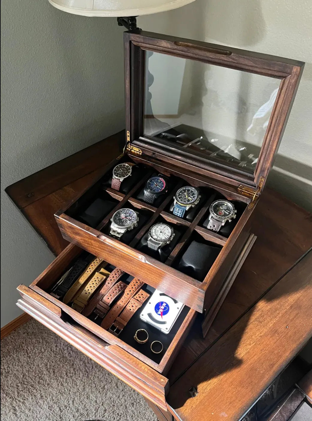 An open handcrafted Deferichs box showing watches above and organized straps below.