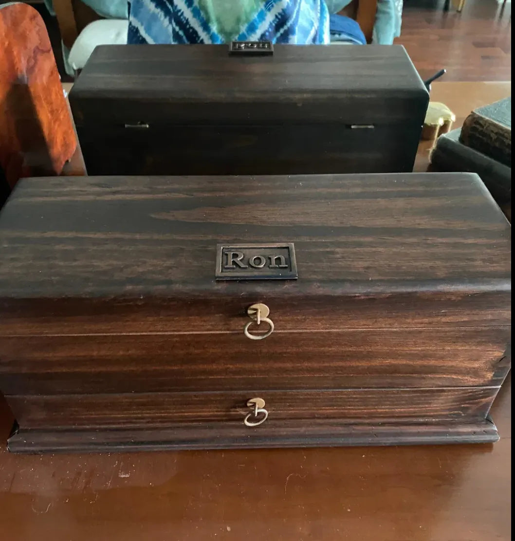 A personalized dark wood Deferichs box with drawers and ring pulls.